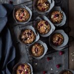 overhead of 10 muffins on a cooling rack with a blue linen.