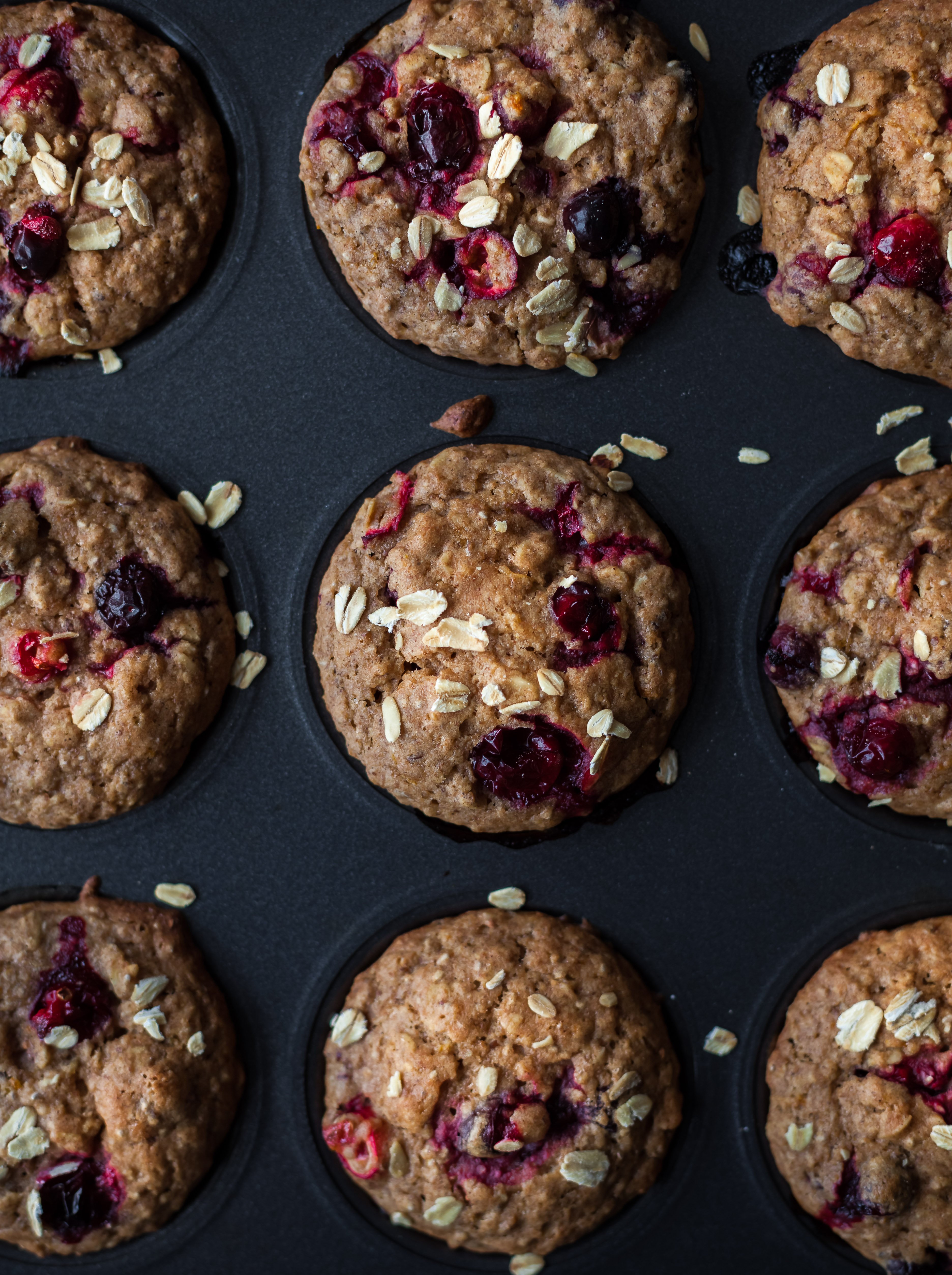an overhead image of vegan cranberry orange muffins in a muffin tin.