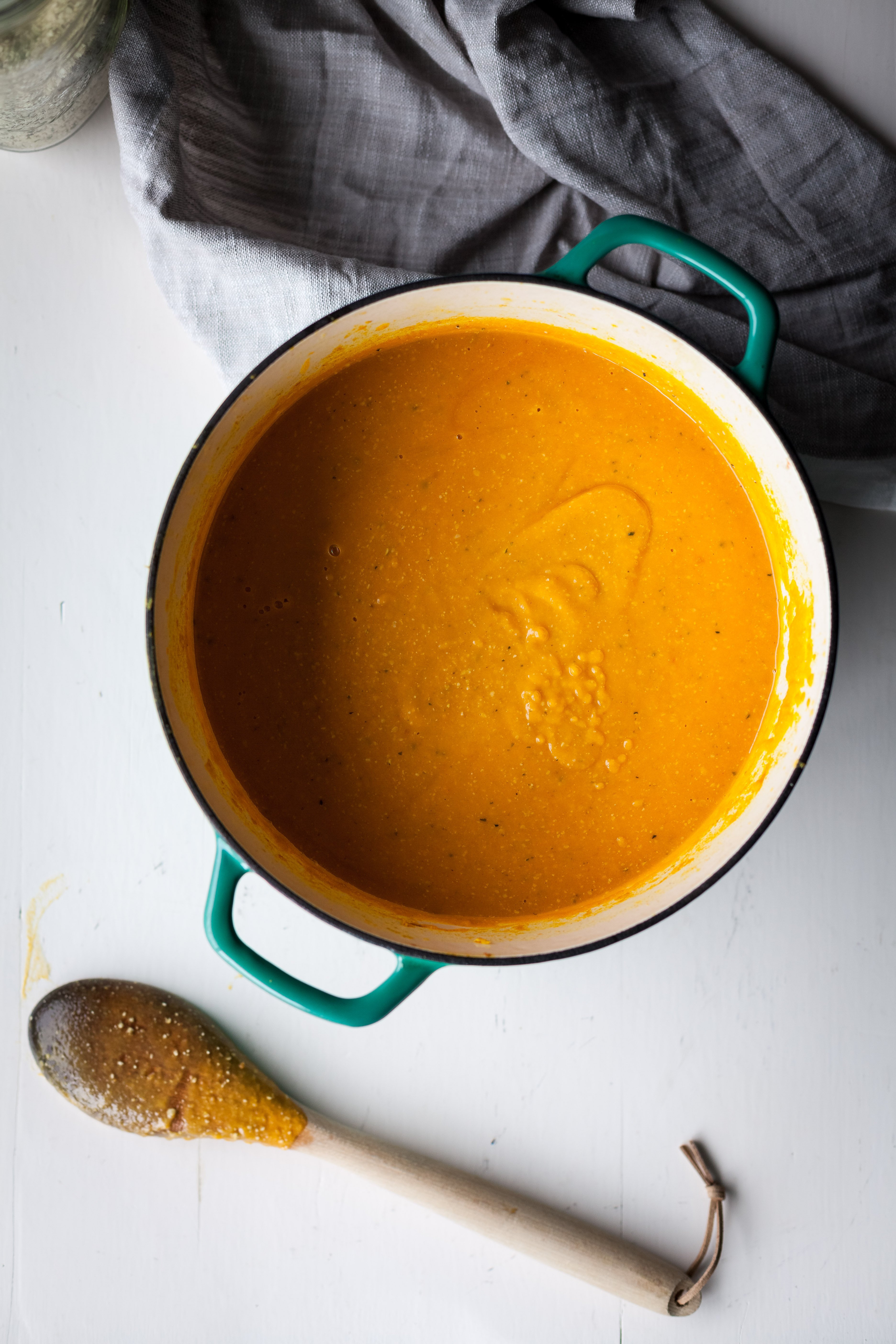 an overhead image of Sweet Potato Lentil and Hemp Soup in a dutch oven with a spoon off to the side.