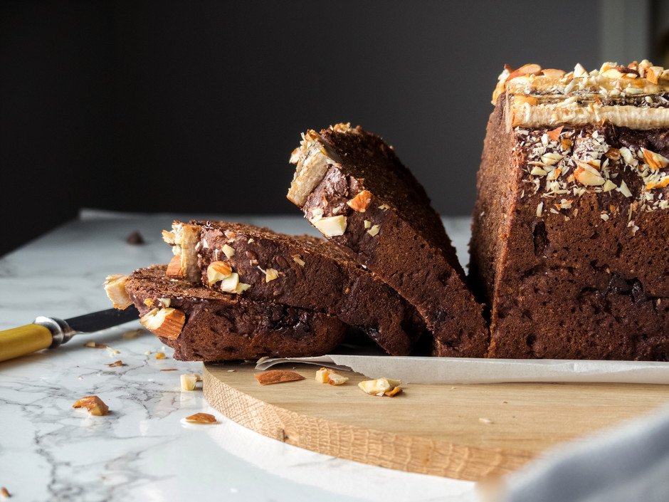 side view of a sliced chocolate banana bread on a cutting board.