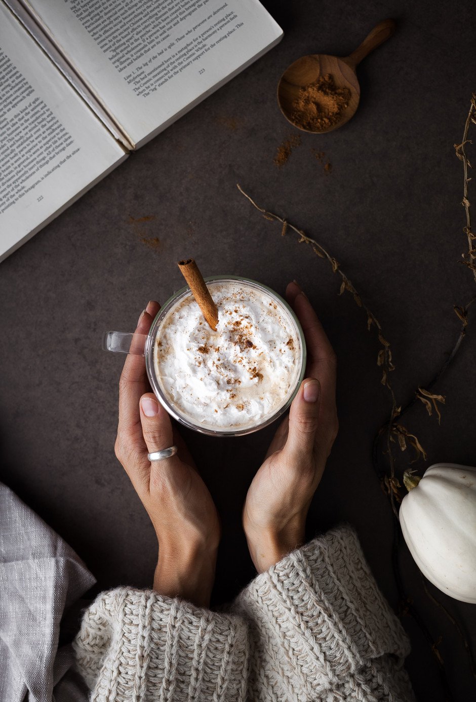 over head image of hands cupping pumpkin spice latte.