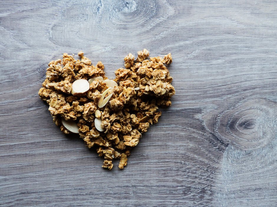 an overhead close up of granola shaped into a heart.