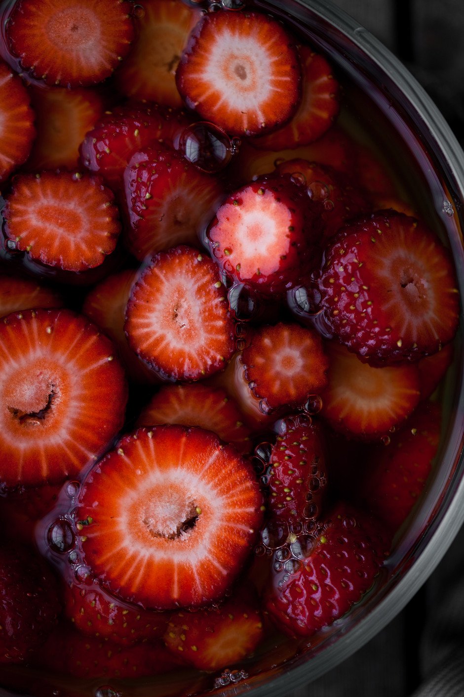 overhead view of sliced strawberries in kombucha.