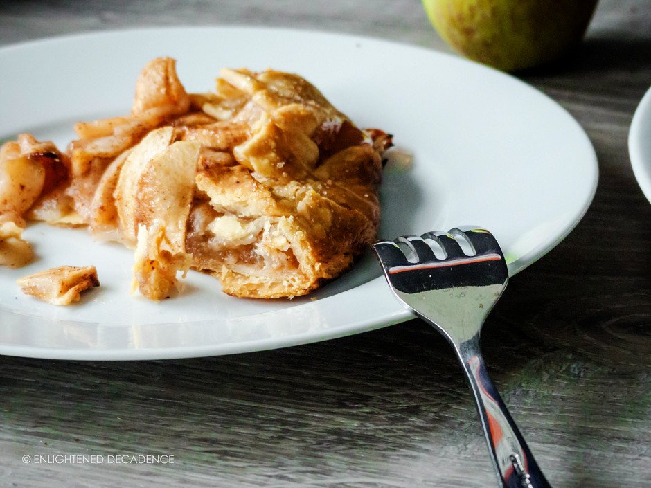 a head on image of a slice of vegan apple galette on a white plate.