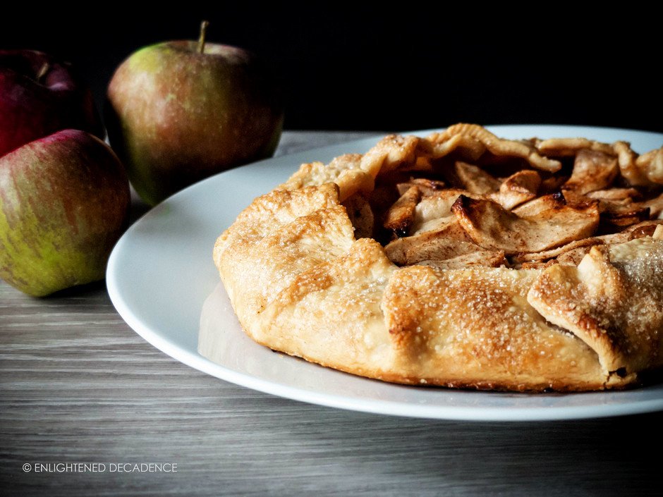 a side view of an apple galette against a black background.