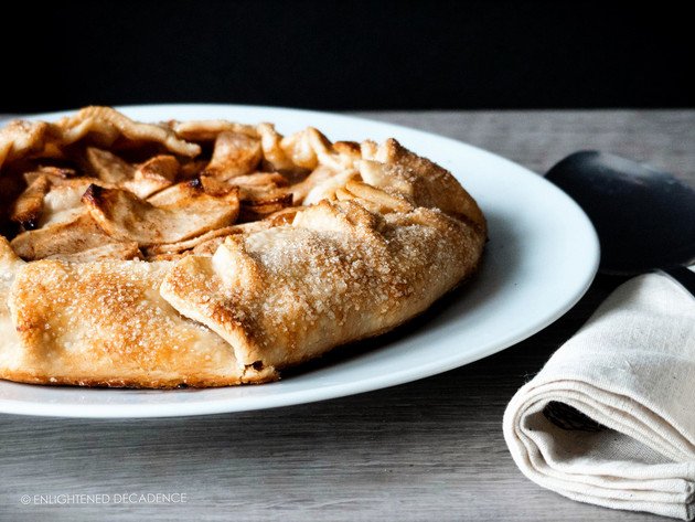 a head on image of a vegan apple galette sitting on a white plate.