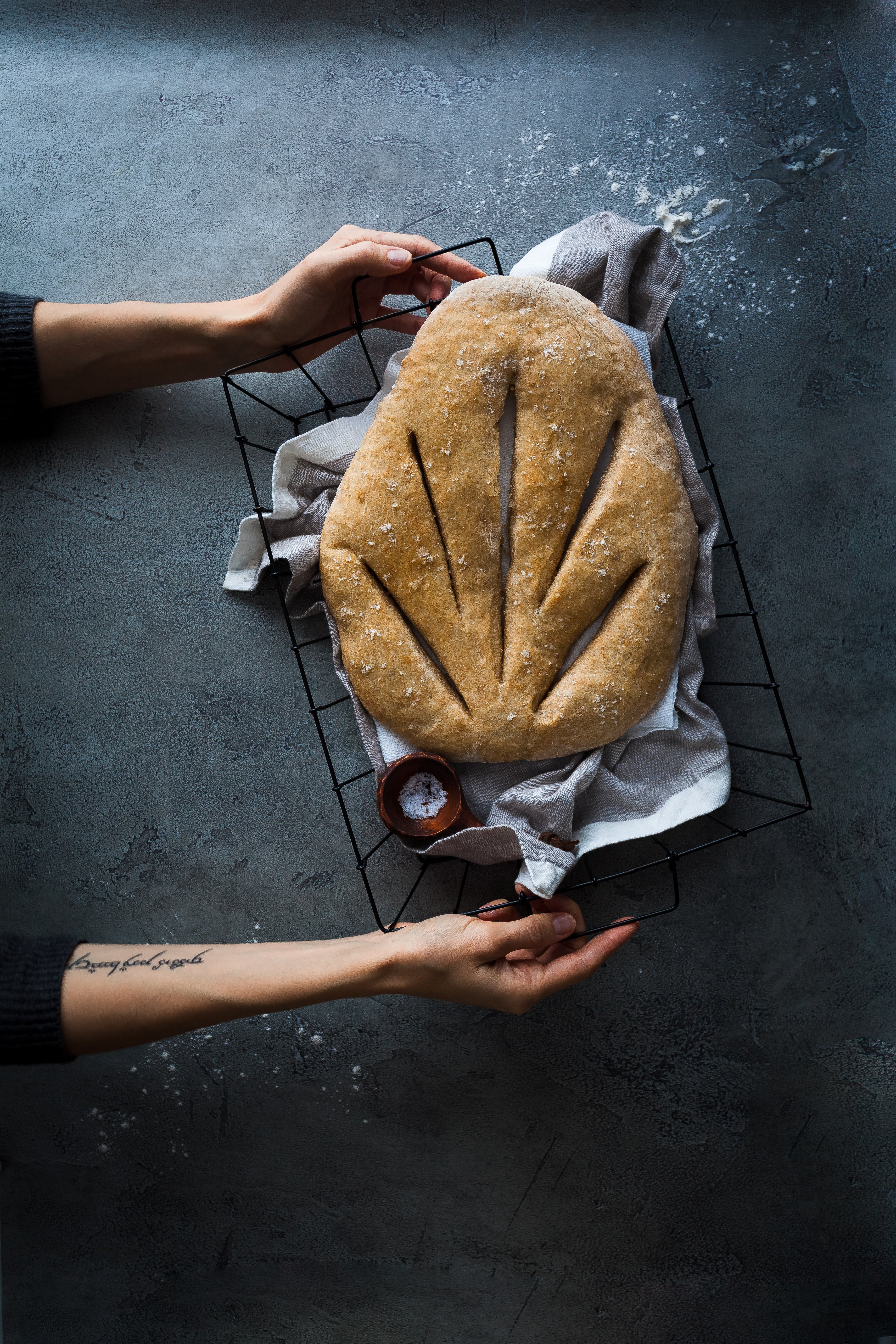 a overhead image of a baker holding a basket of fougasse bread.